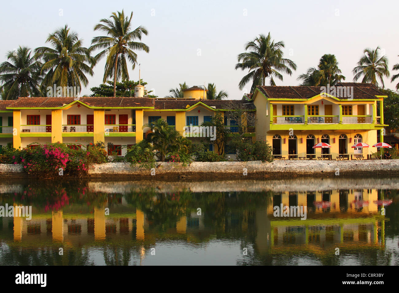 Yellow Riverside Hotel with reflection in Baga, Goa Stock Photo