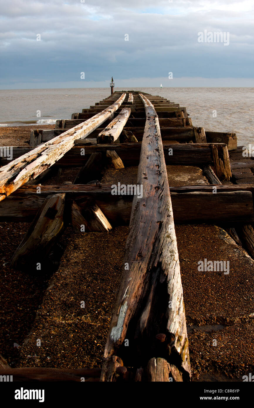 An abandoned railway line going out to sea on Felixstowe beach Stock Photo