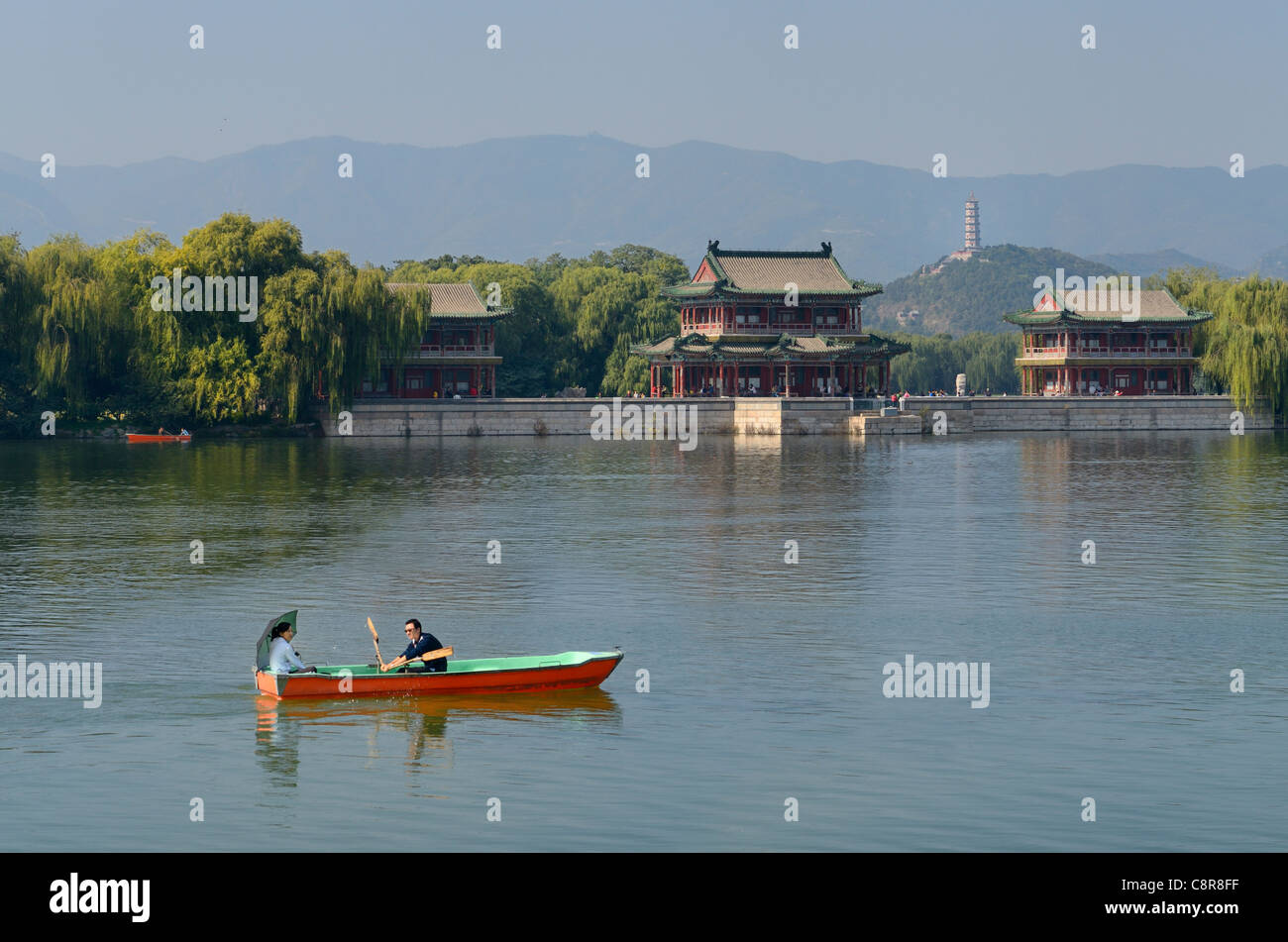 Couple rowing past the Pavilion of Bright Scenery with Jade Peak Pagoda on Kunming Lake Summer Palace Beijing Peoples Republic of China Stock Photo