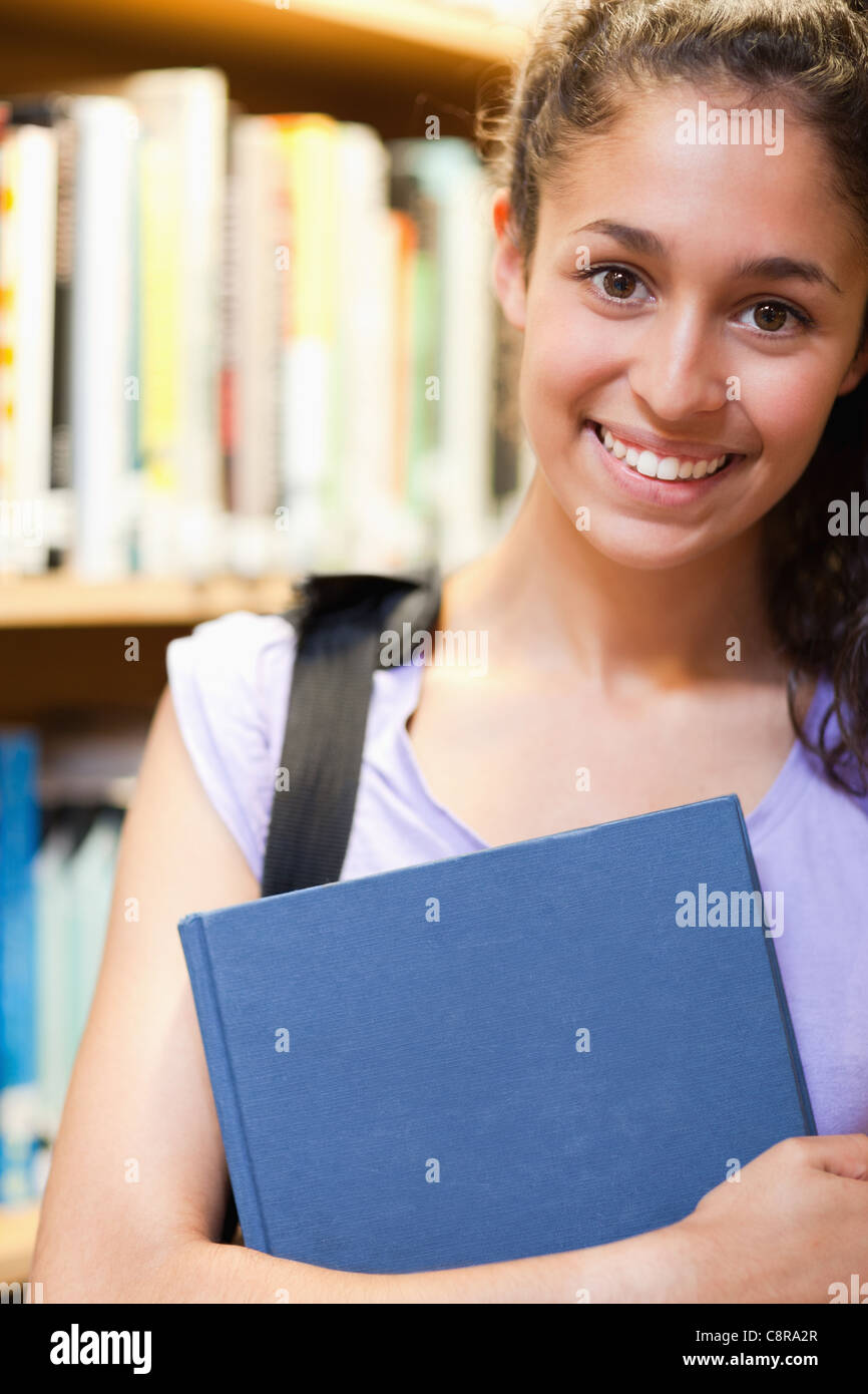 Portrait of a happy female student holding a book Stock Photo - Alamy