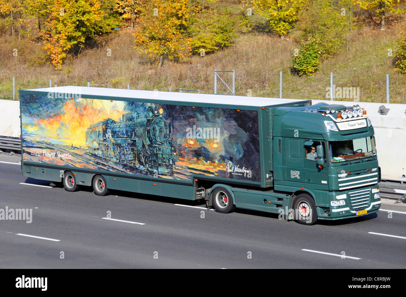 Engine artwork by graphic artist Paul Kerrebijn on side of Dutch flower supplier articulated trailer HGV lorry truck driving motorway road England UK Stock Photo