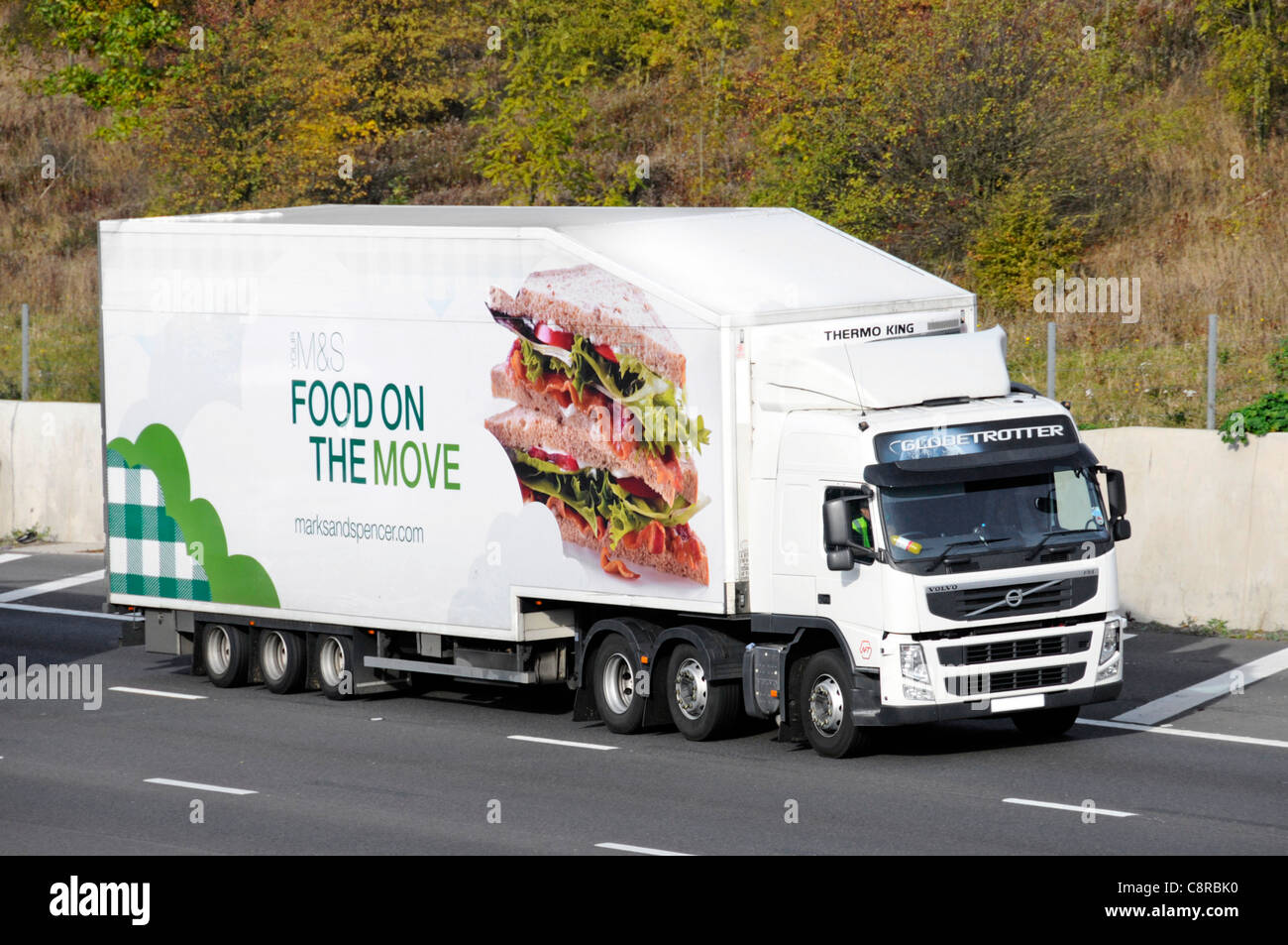 M&S food delivery supply chain articulated trailer elaborate graphics advertising food on the move and Volvo hgv lorry truck driving on UK motorway Stock Photo