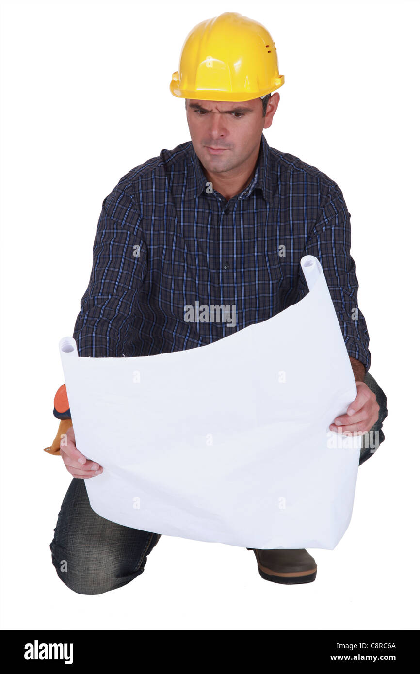 Angry Draftsman Angry tradesman looking at a technical drawing Stock Photo - Alamy