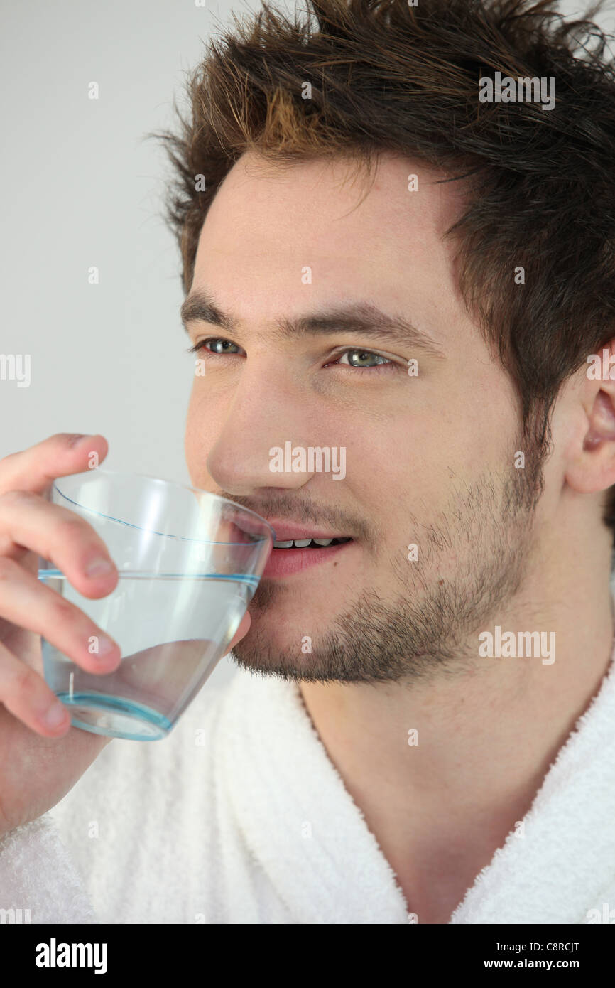 Young man drinking a glass of water Stock Photo Alamy