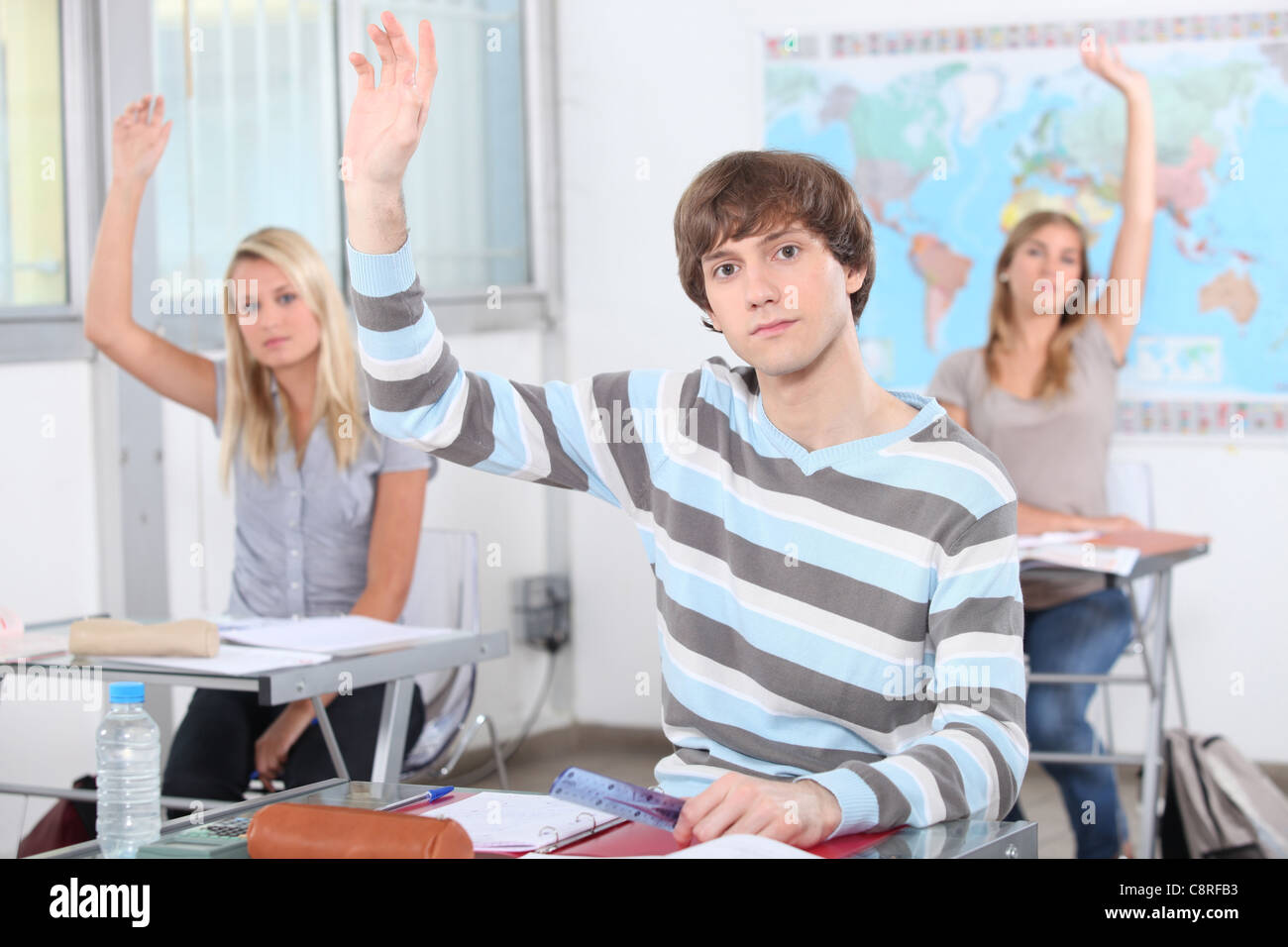 школьник поднимает руку. студент поднял руку на уроке. студент тянет руку. студент поднимает руку. поднятая рука в аудитории.