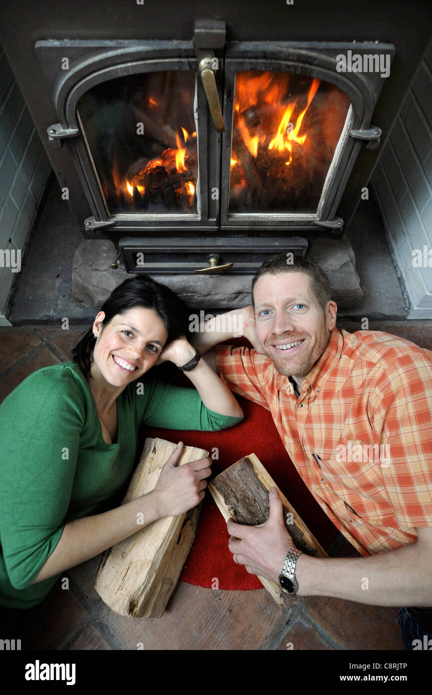 A family using a solid fuel wood burning stove to heat their house UK