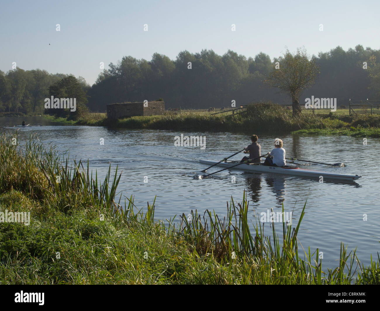Two people rowing in a canoe early in the morning, on the River Stour at Sudbury in Suffolk, England. Stock Photo