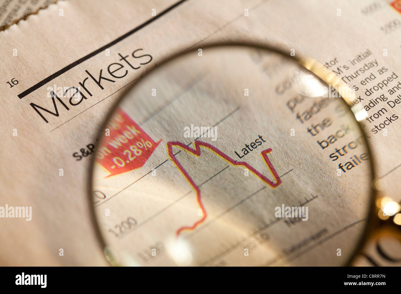 Magnifying glass enlarging stock market chart Stock Photo