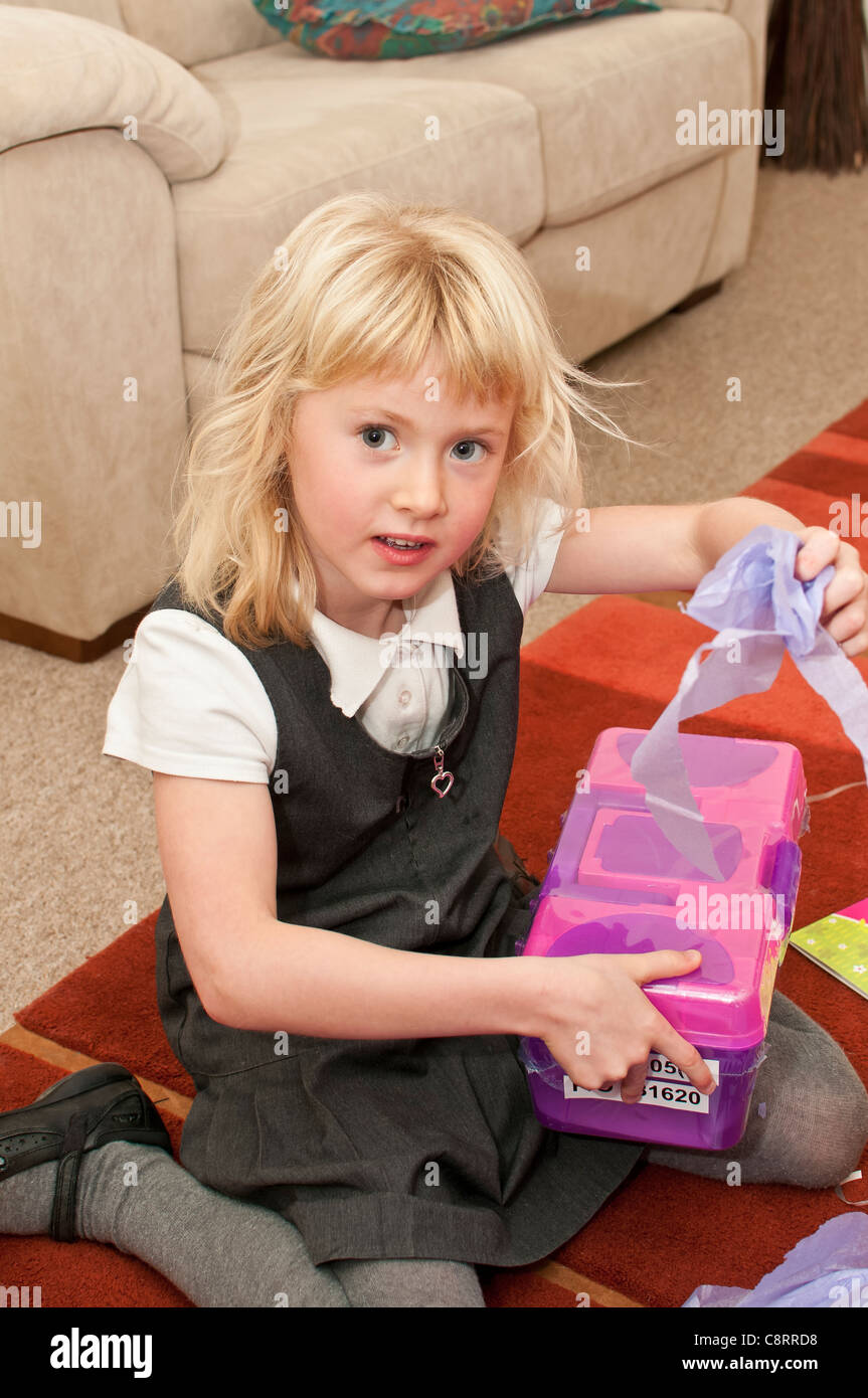 young six year old girl opening present birthday Stock Photo