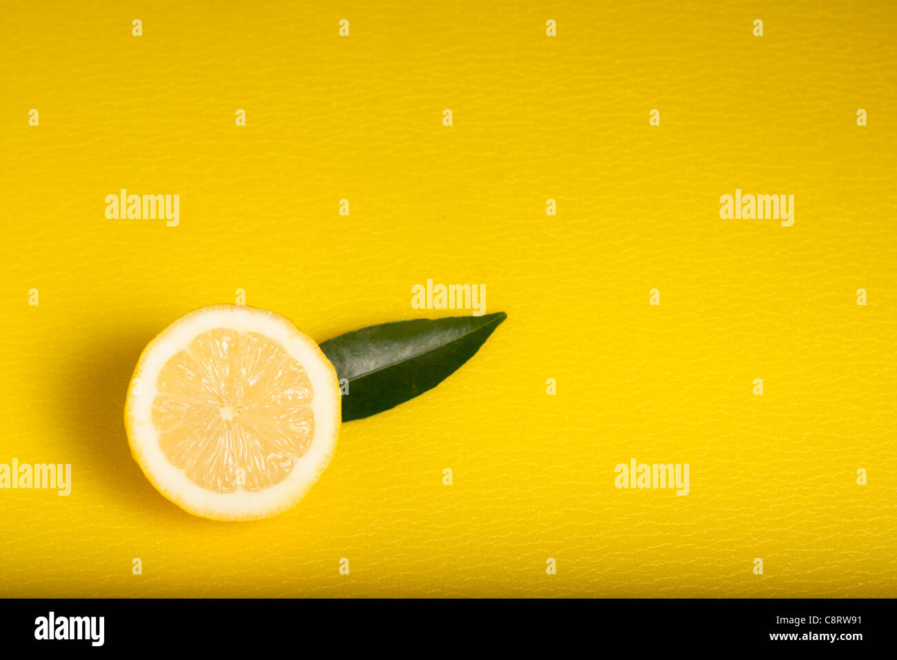 Half Lemon on Yellow Background Stock Photo