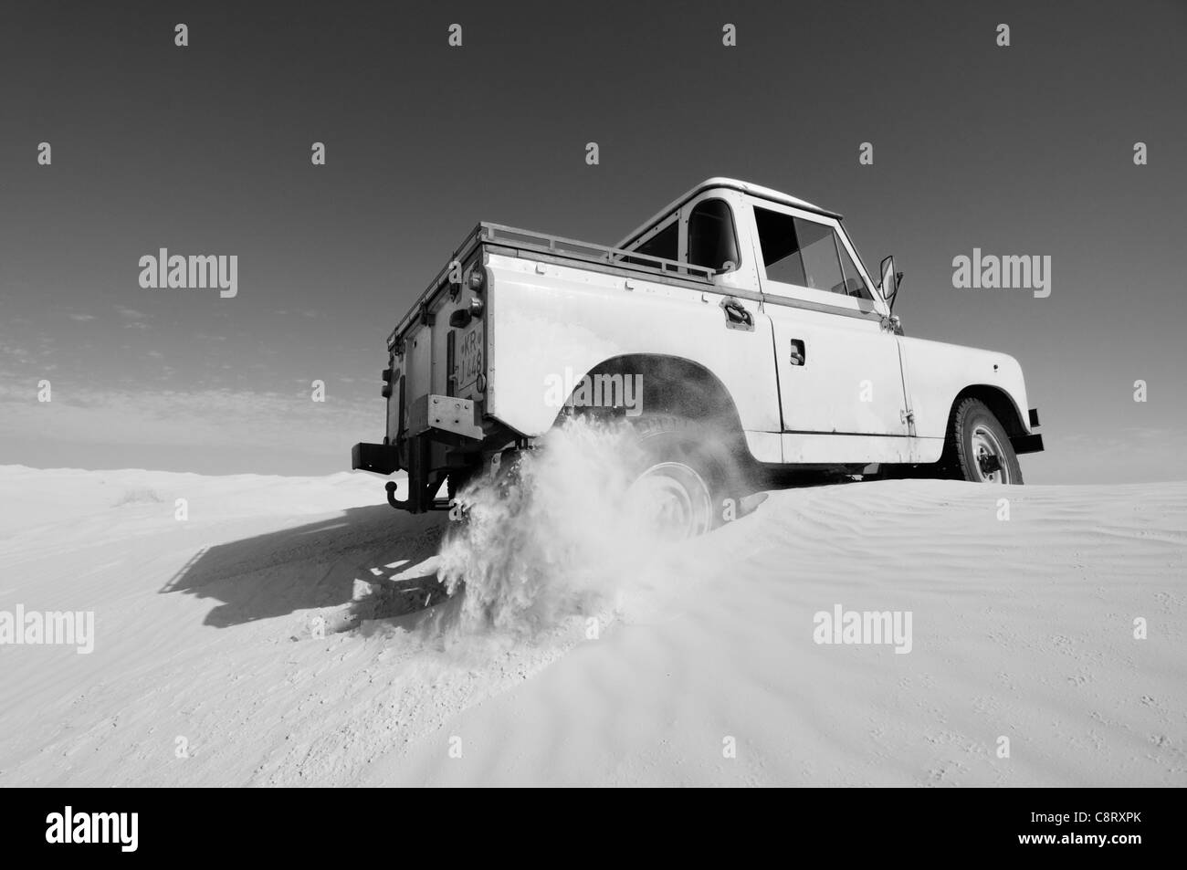 Africa, Tunisia, nr. Tembaine. Desert traveller driving his 1964 Land Rover Series 2a Truck Cab through a sandfield close to ... Stock Photo