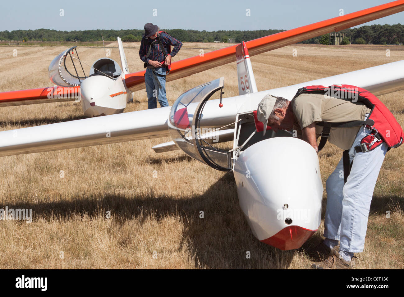Two glider pilots prepare their aircraft for flight Stock Photo