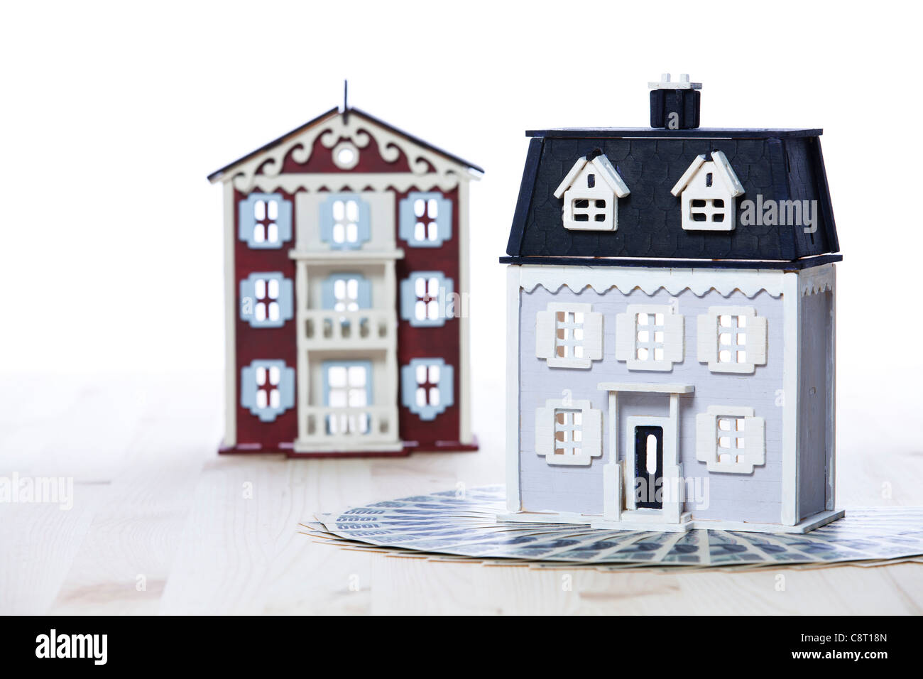 Model houses with money against white background Stock Photo