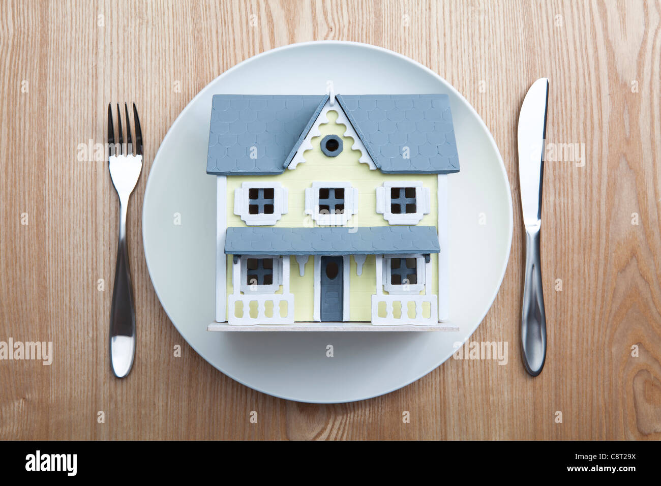 Top view of architectural model placed in plate with fork and knife on table Stock Photo