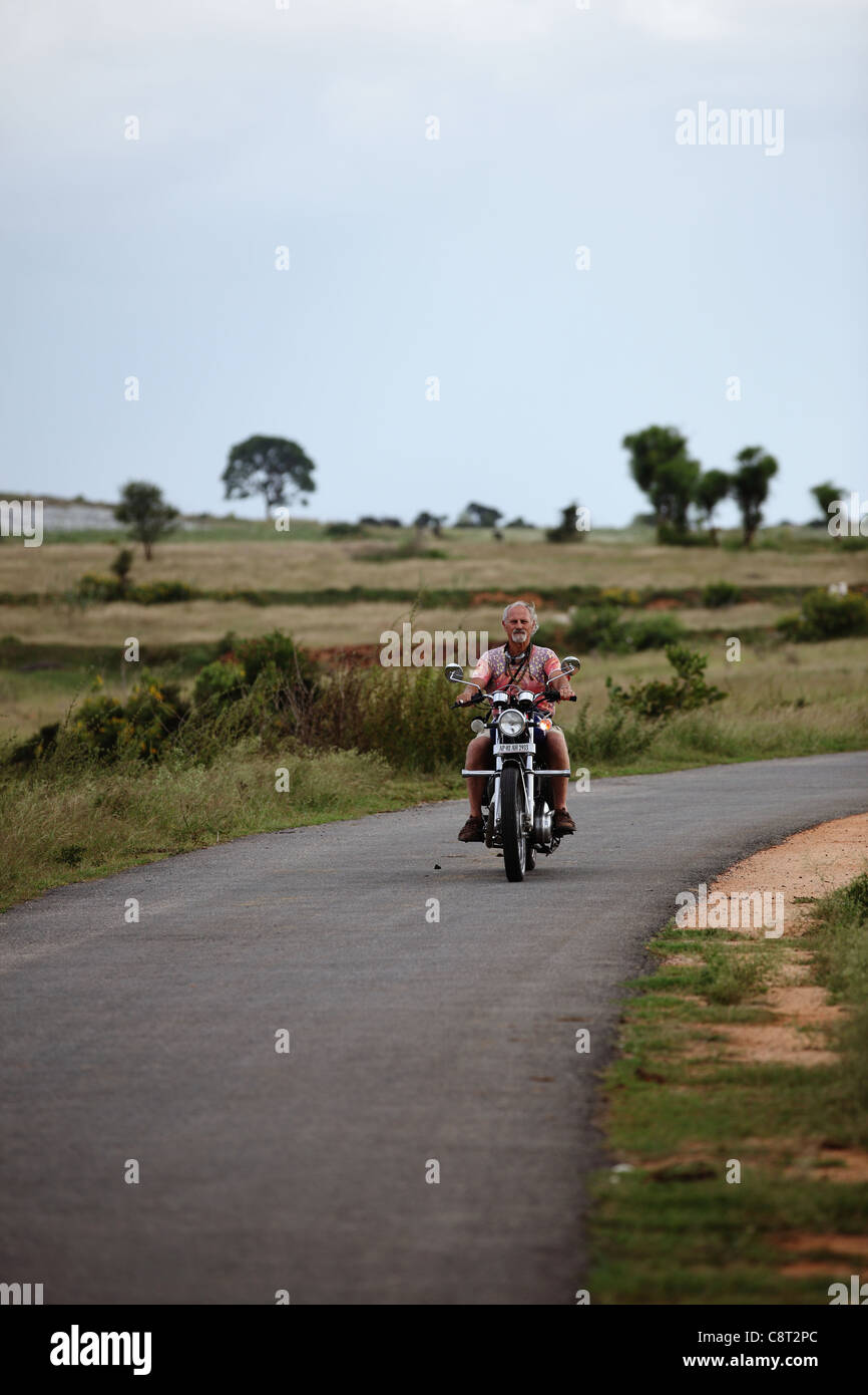 European man driving a Bullet Enfield in Andhra Pradesh South India Stock Photo