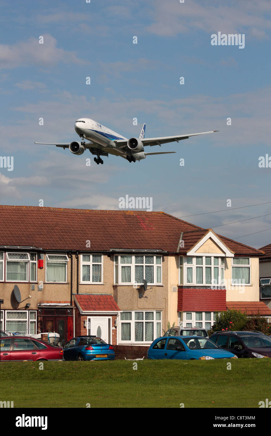 ANA Boeing 777-300ER overflying a residential area on final approach to Heathrow Airport Stock Photo