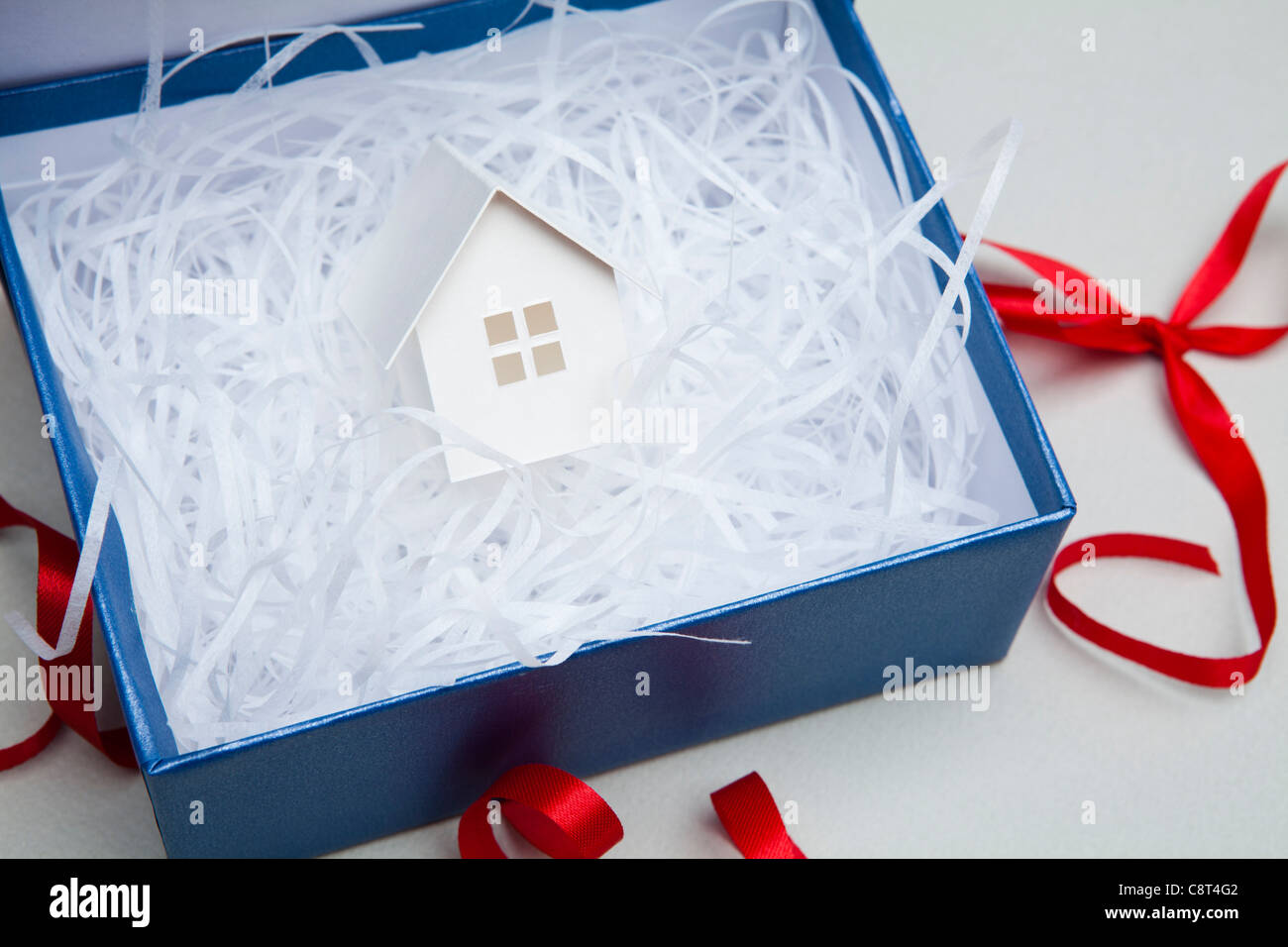 Gift With Red Ribbon And House Model Stock Photo
