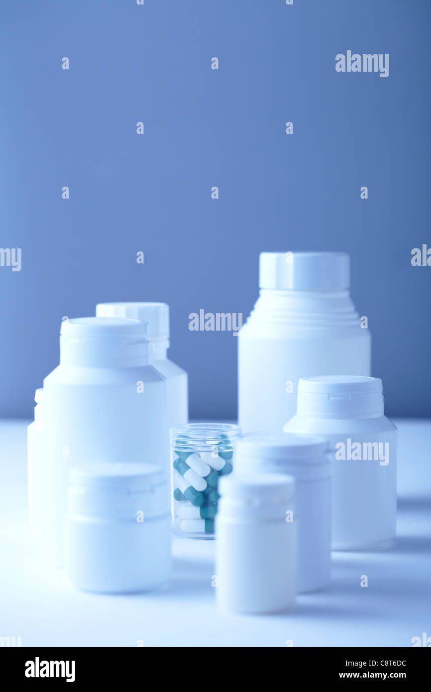 Plastic pill bottles against colored background Stock Photo