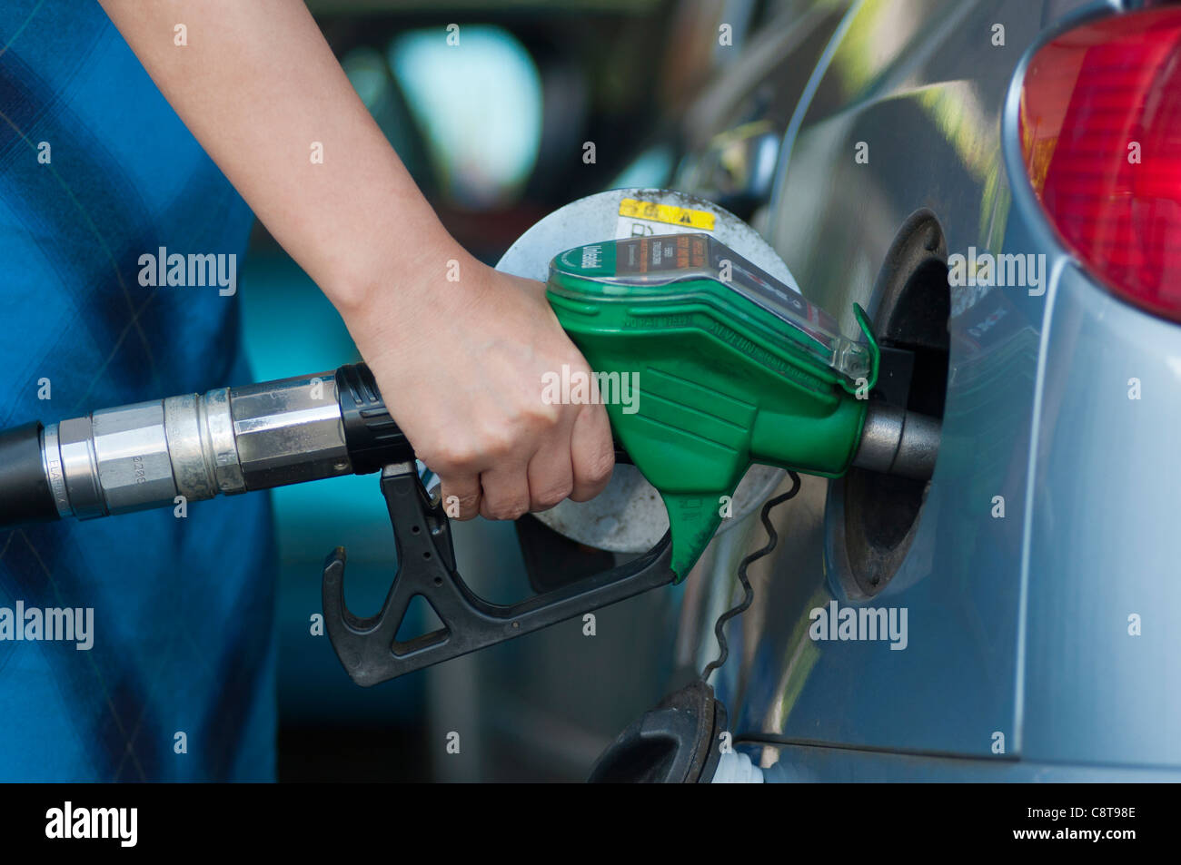 Woman filling up a car with petrol. UK Stock Photo