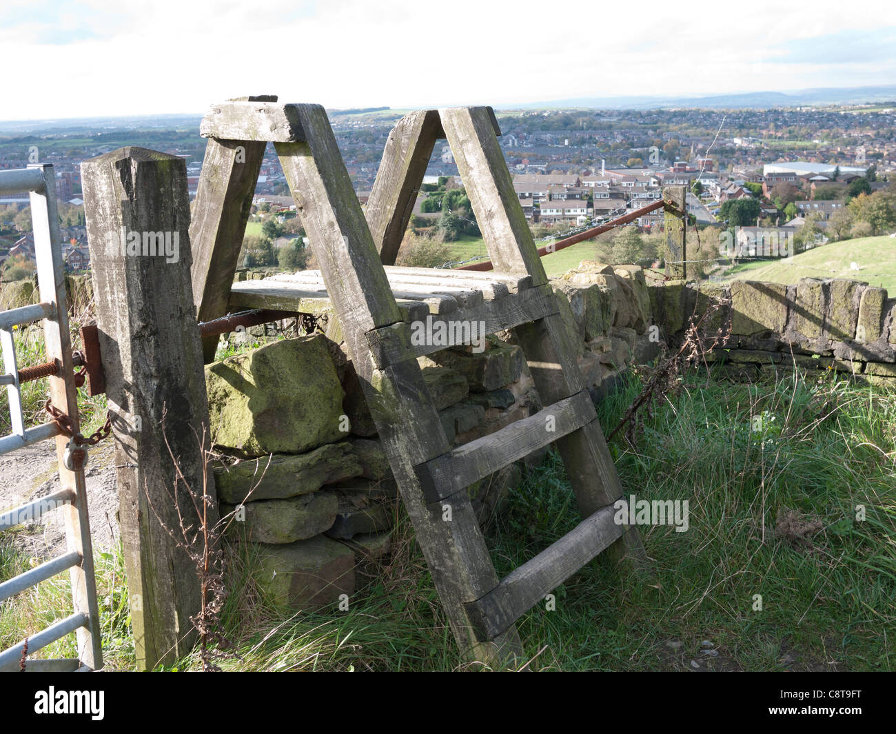 Wooden Stile over a stone wall overlooking Shaw, Lancashire, England UK