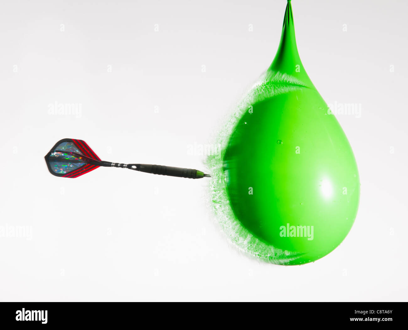 Studio shot of dart puncturing waterfilled balloon Stock Photo Alamy