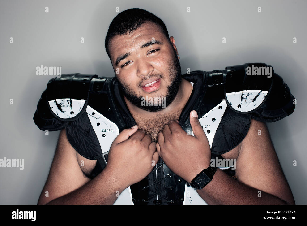 Mixed race man in football shoulder pads Stock Photo