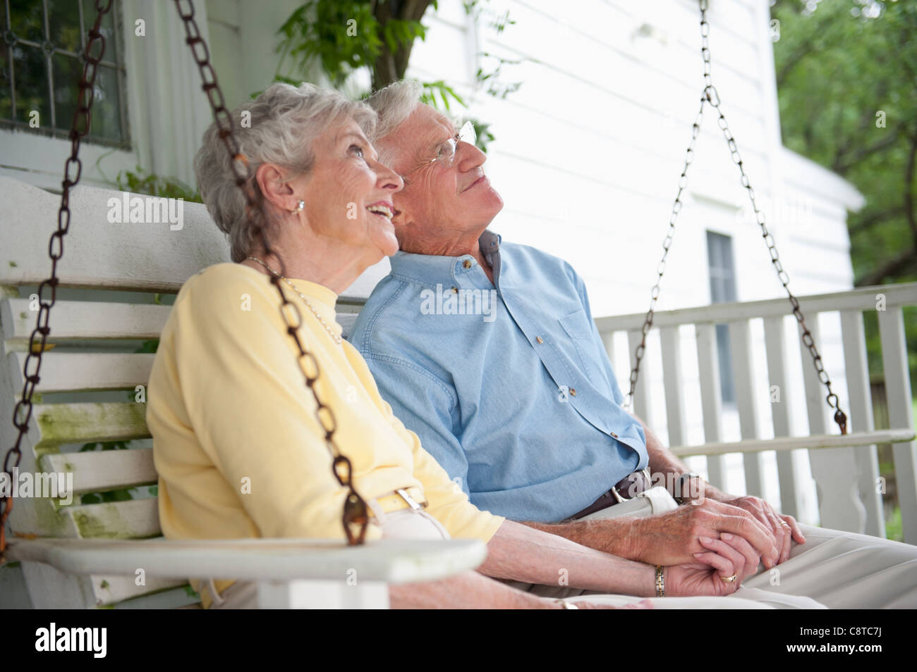 USA, New York State, Old Westbury, Senior couple sitting on porch swing Stock Photo