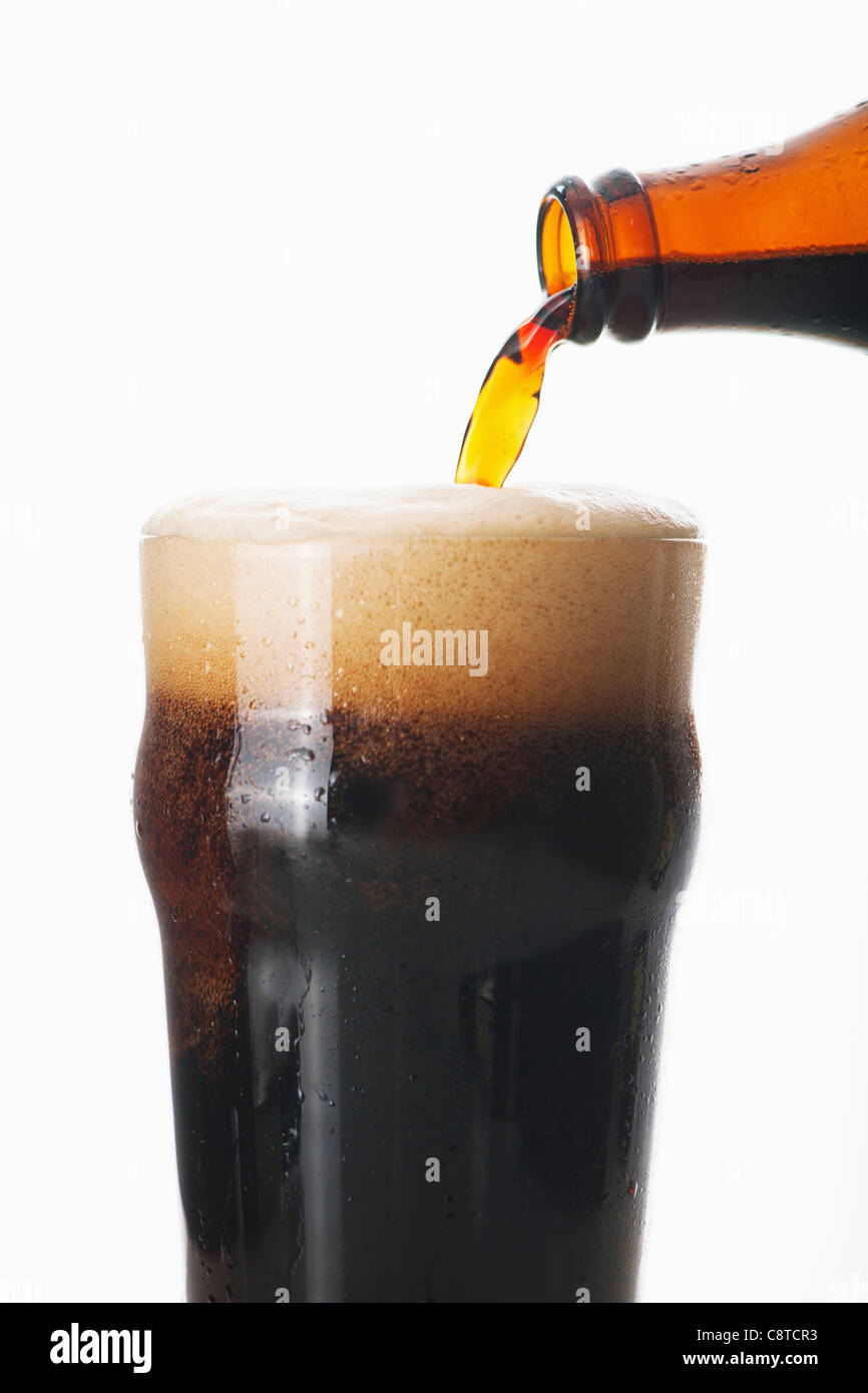 Ale pouring into glass, studio shot Stock Photo