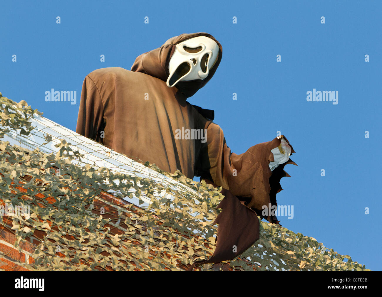 Demon on rooftop speaking to the masses below. Stock Photo