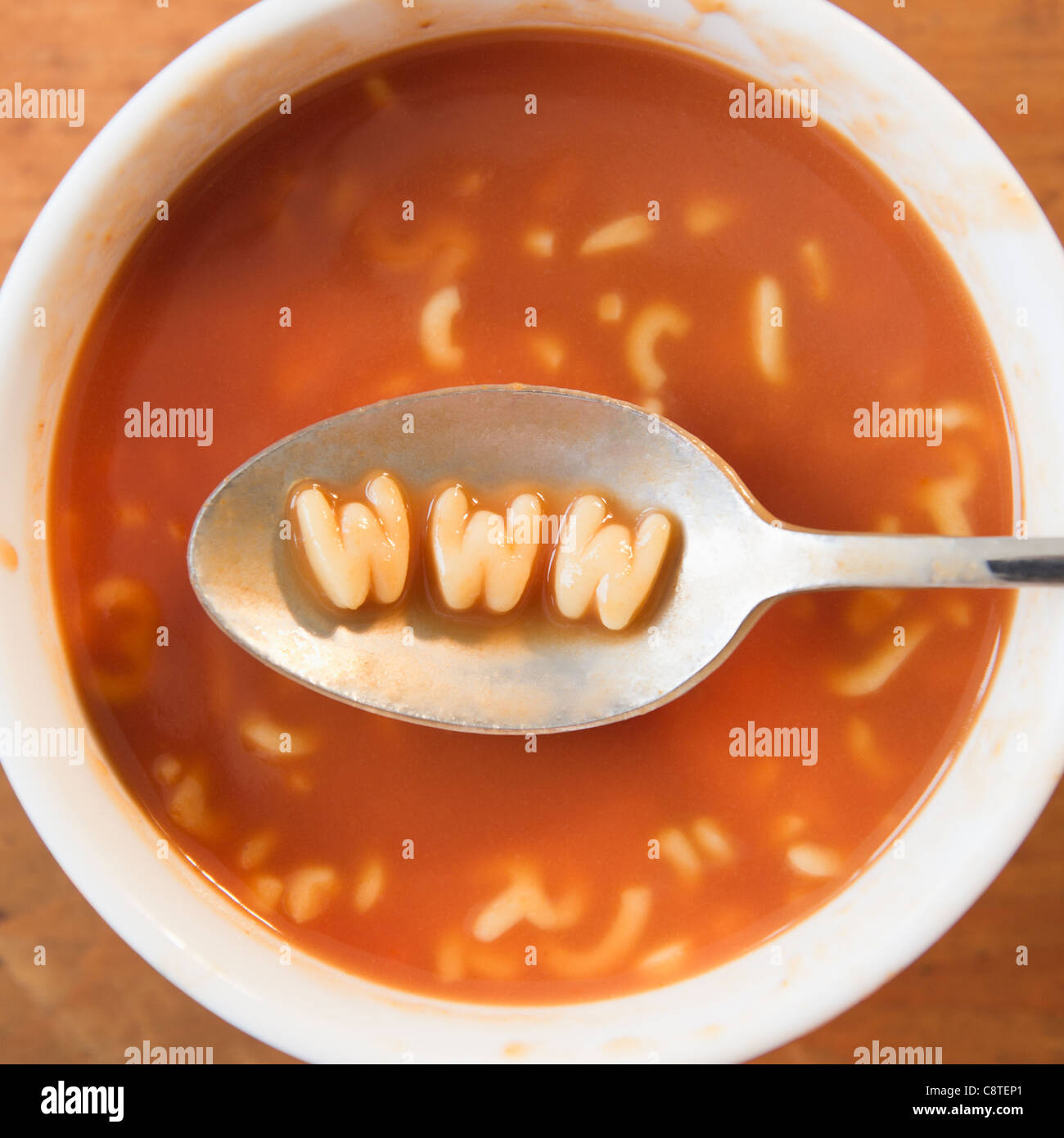 Close up of soup with letter noodles on spoon forming www site Stock Photo