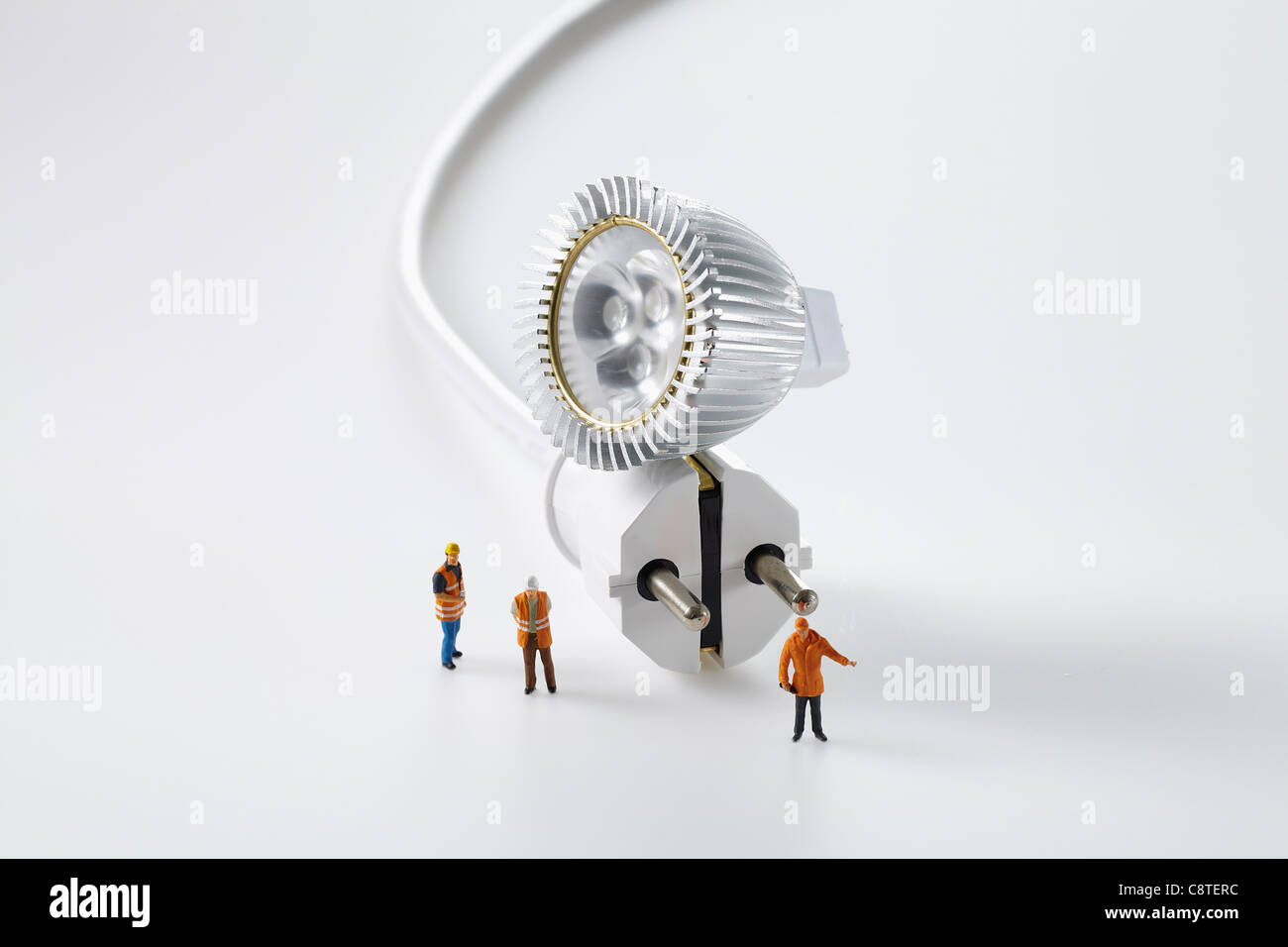 Close-up of electrical plug with small figurines Stock Photo - Alamy