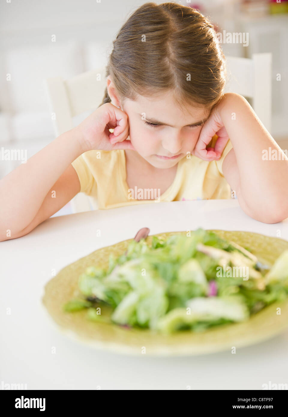 USA, New Jersey, Jersey City, Upset girl sitting at table with salad meal Stock Photo