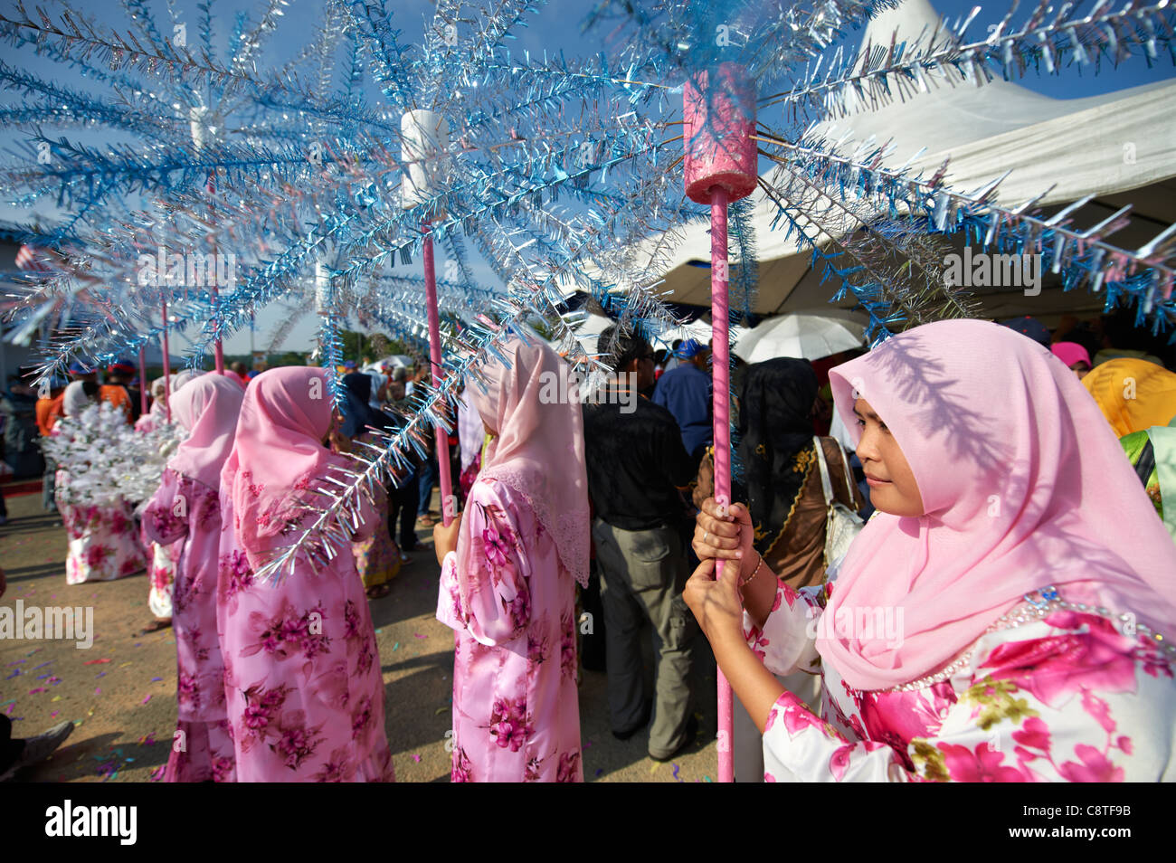 Malaysian women dressed in traditional wear holding festive decorations. Stock Photo