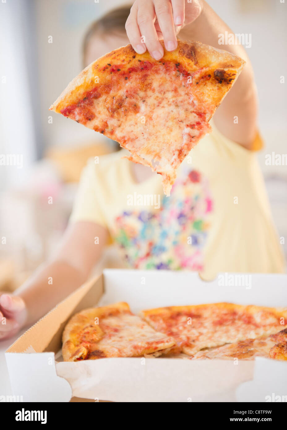 USA, New Jersey, Jersey City, Girl showing slice of pizza Stock Photo
