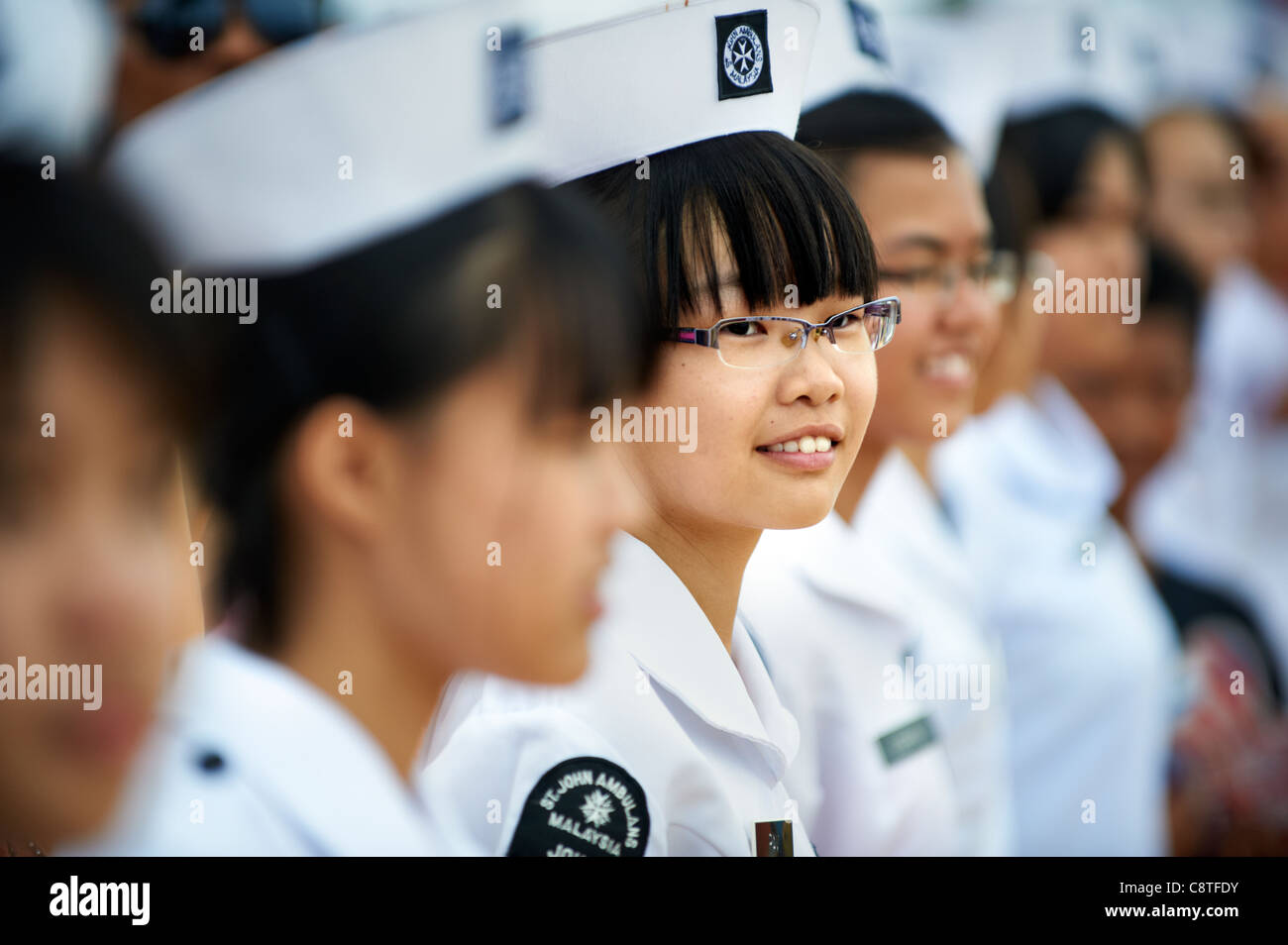 Young female nurses representing St. John Ambulance of Malaysia lined up in uniforms. Stock Photo