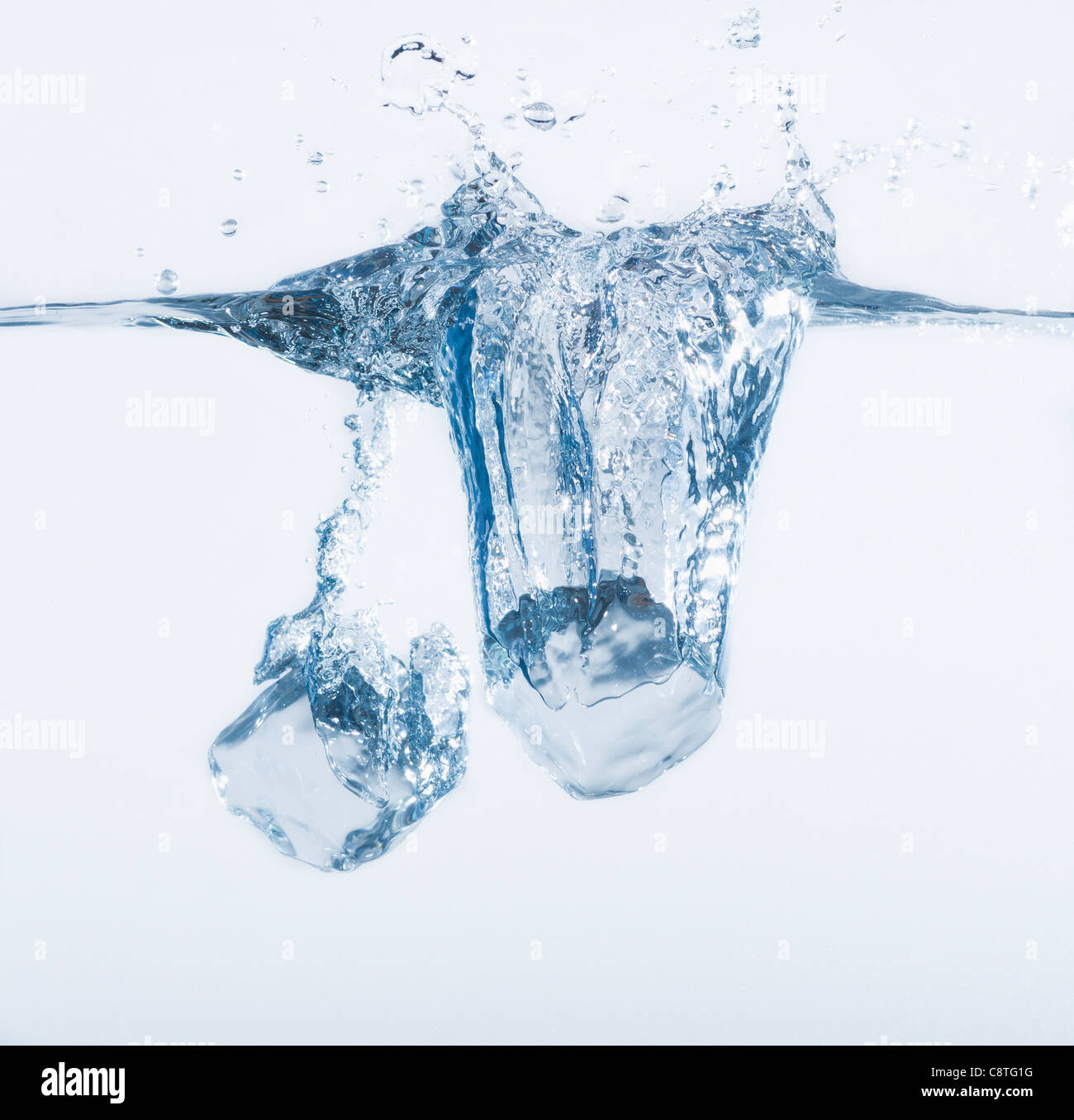 Two ice cubes splashing into water, studio shot Stock Photo - Alamy