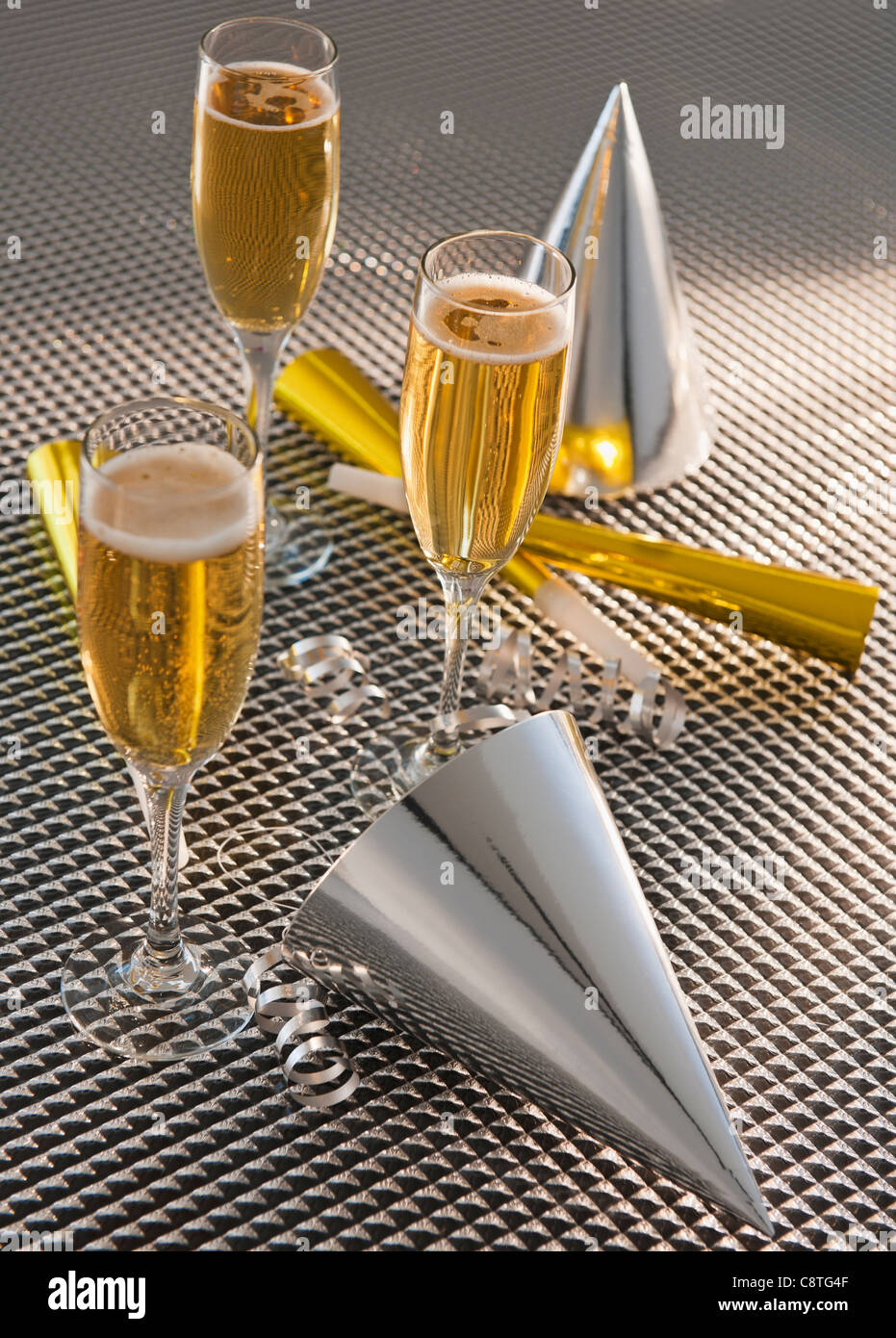 Flutes with champagne, party horn blowers and paper party hats Stock ...