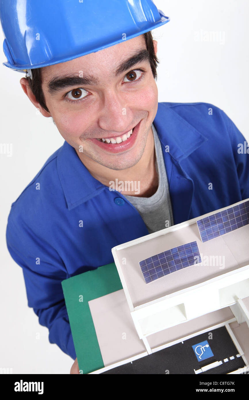 Happy builder stood with model house Stock Photo - Alamy