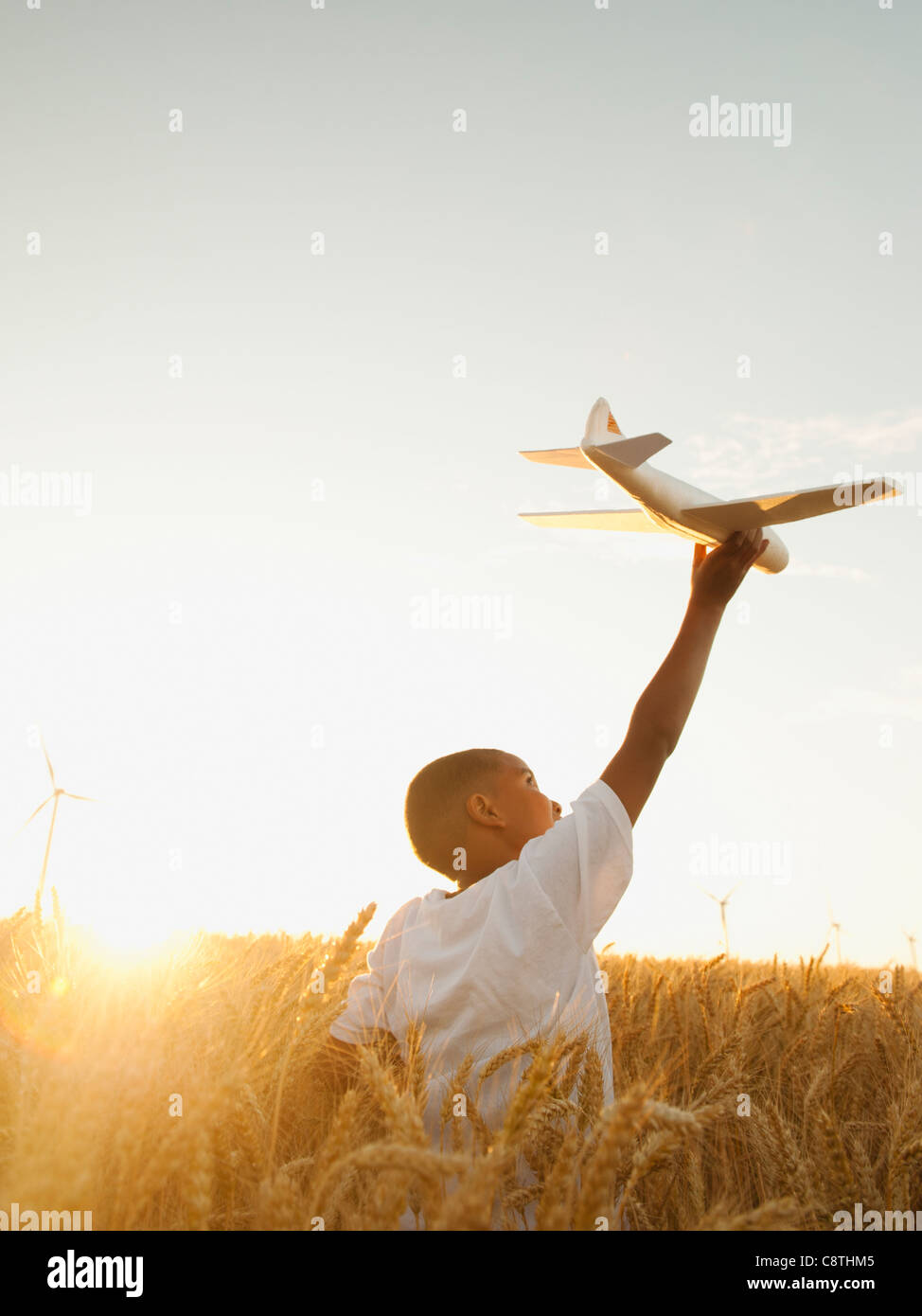 USA, Oregon, Wasco, Boy playing with toy aeroplane in wheat field Stock Photo