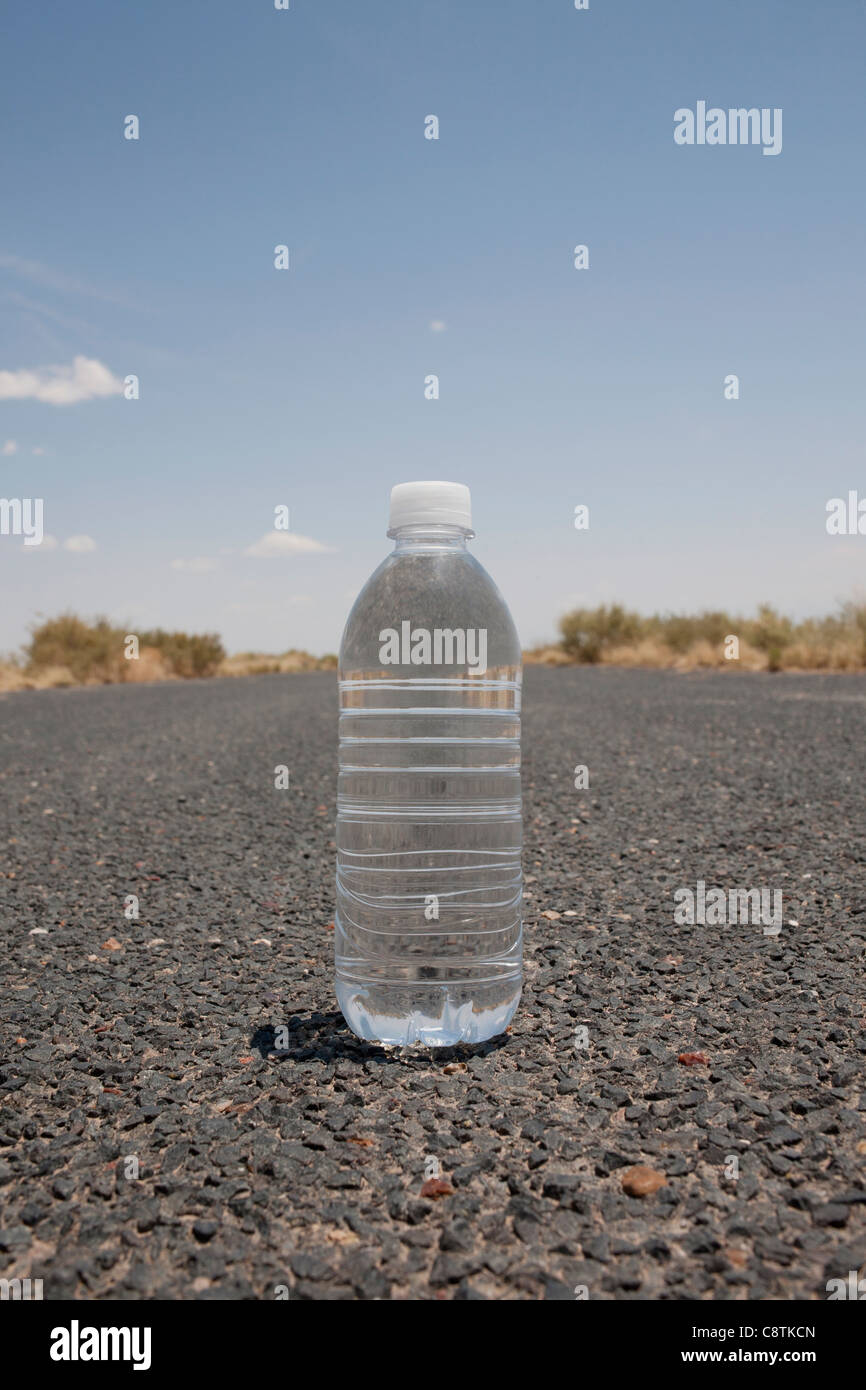 USA, Arizona, Water bottle sitting in middle of desert road Stock Photo