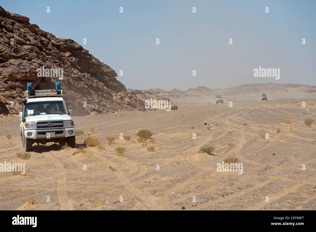 Long shot of four wheel drive vehicles, approaching camera kicking up dust trails in Egypt's Eastern desert Stock Photo