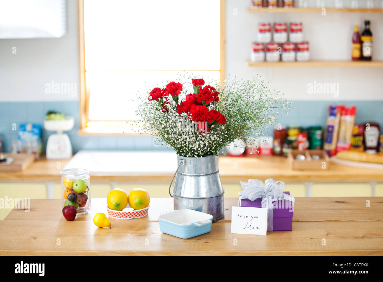 Wrapped Gift Box And Bunch Of Flower On The Kitchen Counter Stock Photo
