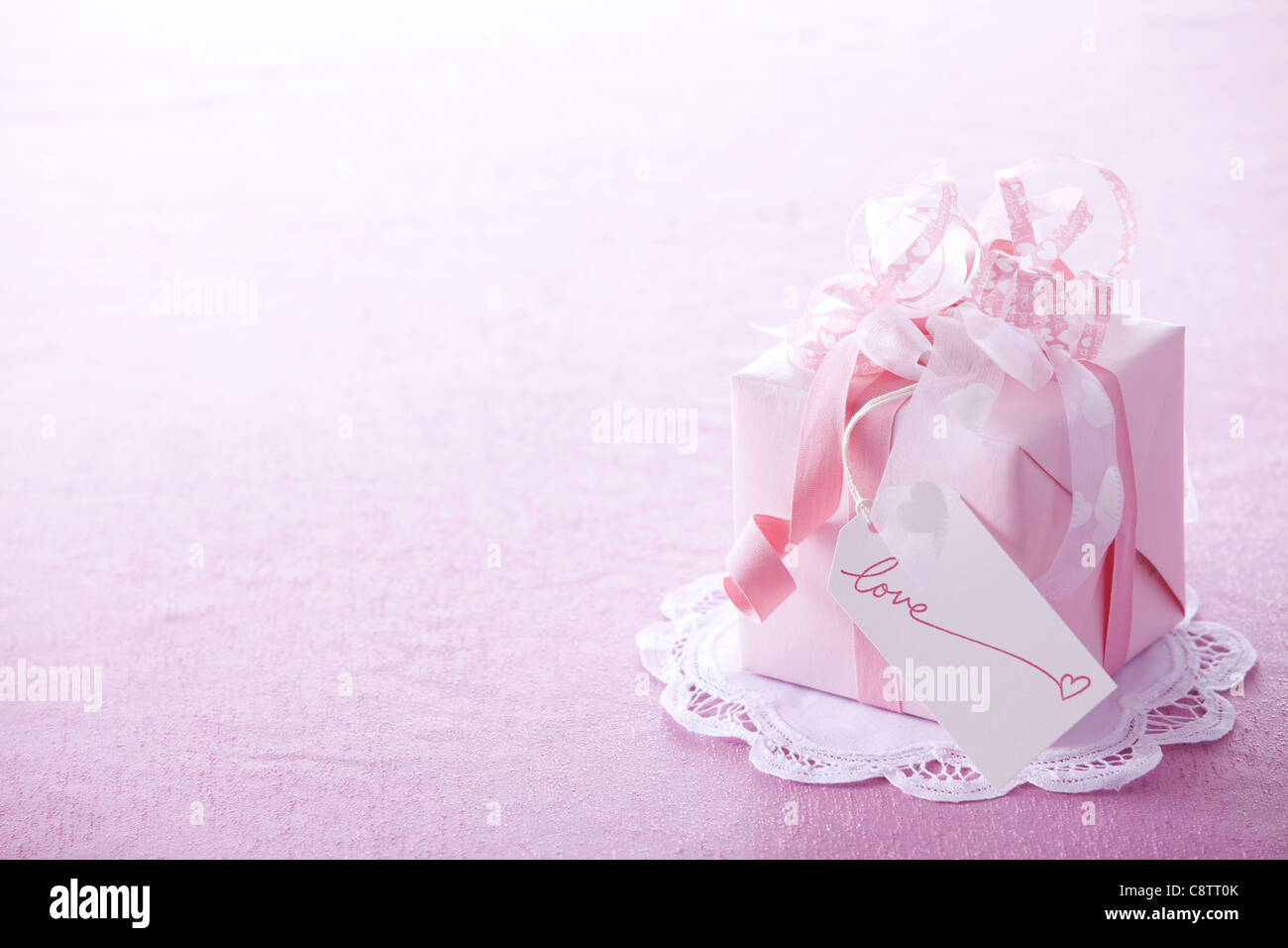 Wrapped Valentine's Day Gift On Top Of Paper Doily With Gift Tag Stock Photo