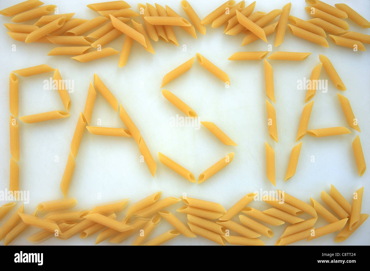 Pasta spelled out using penne pasta on a white background Stock Photo
