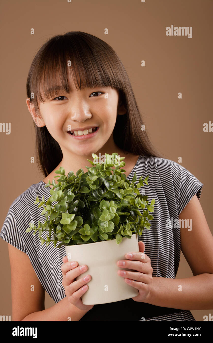 Studio portrait of girl holding potted plant Stock Photo
