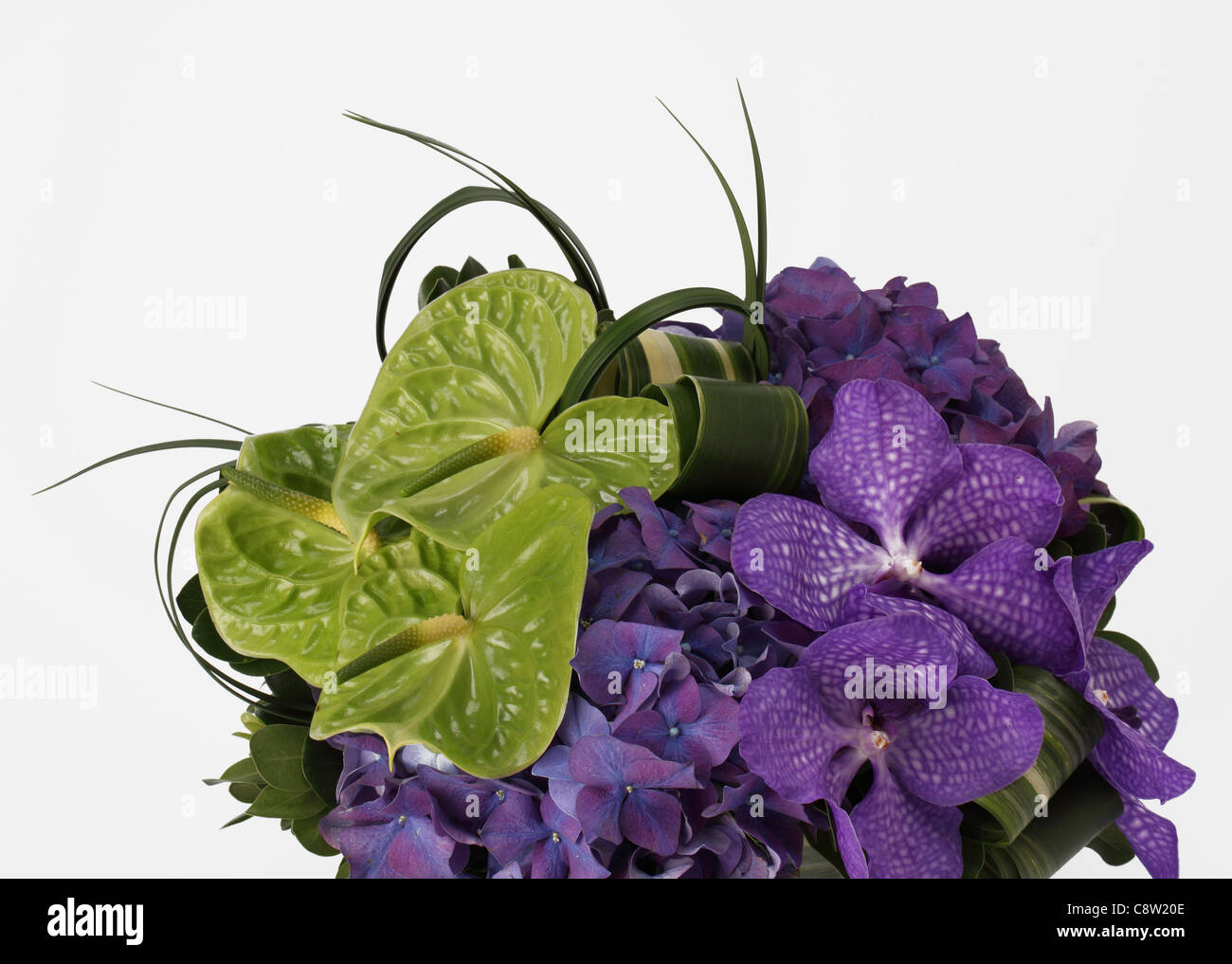 A close-up of a colorful bouquet of flowers. Purple vanda orchids, green anthuriums, purple hydrangea. Stock Photo