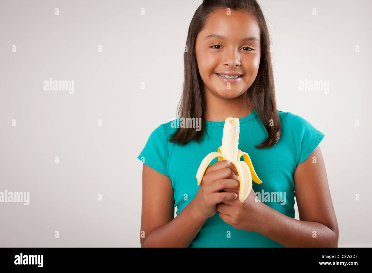 Studio portrait of girl holding banana Stock Photo Alamy
