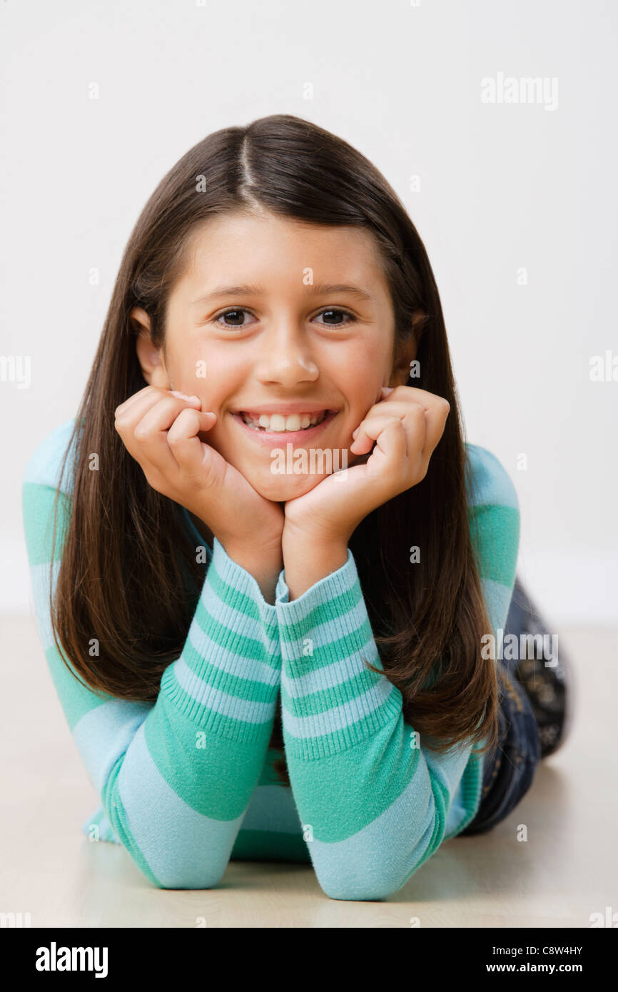Studio portrait of girl lying on floor Stock Photo - Alamy