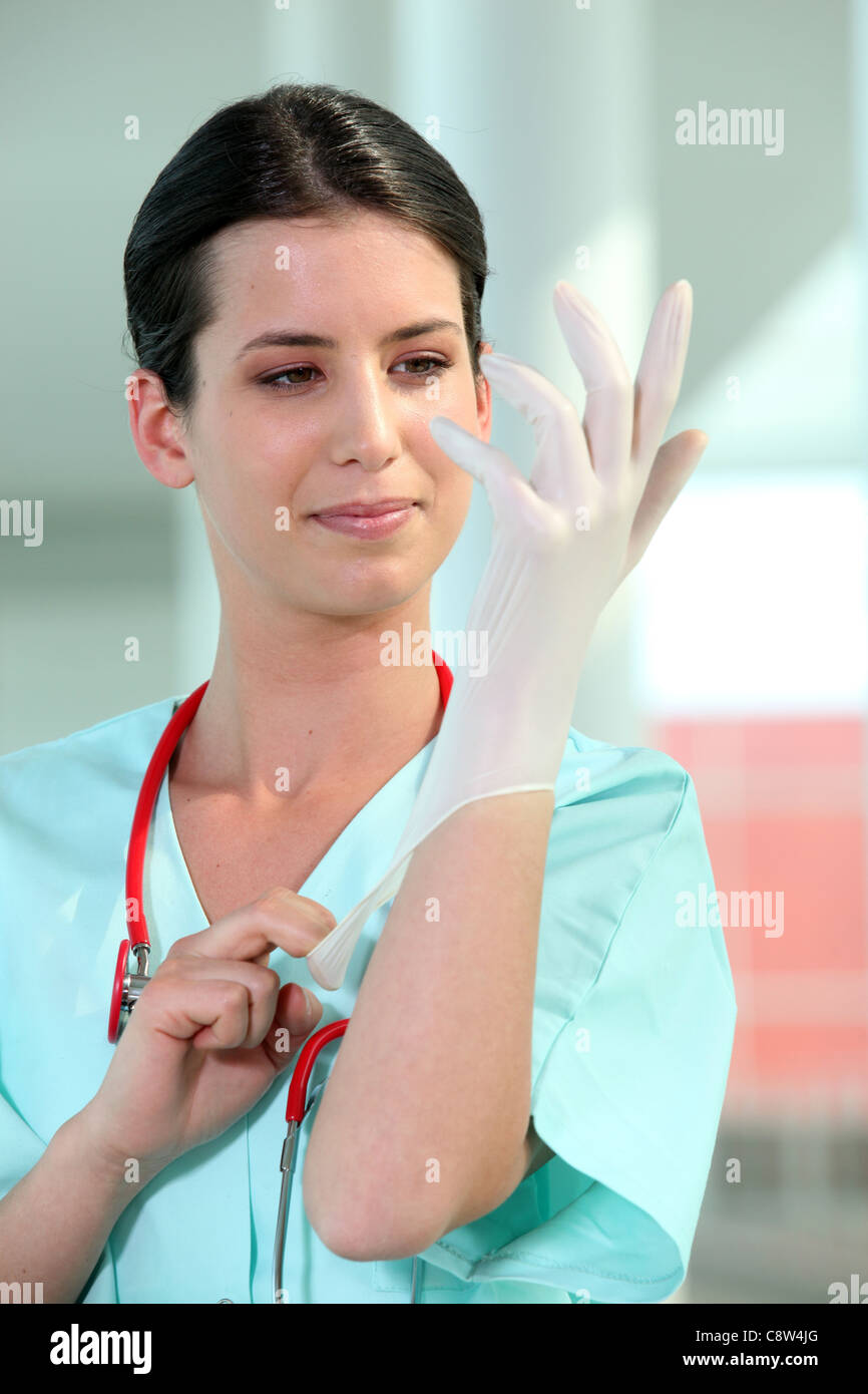 female doctor putting on rubber gloves Stock Photo
