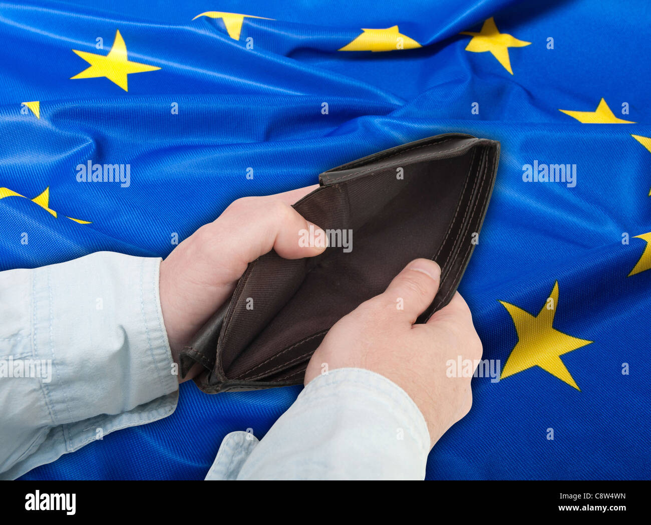 Financial Crisis in EU - Man's Hand With Empty Wallet and Flag of European Union Stock Photo